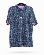 Men’s Daisy Daze golf polo by Pins & Aces featuring an all-over pink, blue, and white daisy floral print on a navy background with an athletic performance fit.