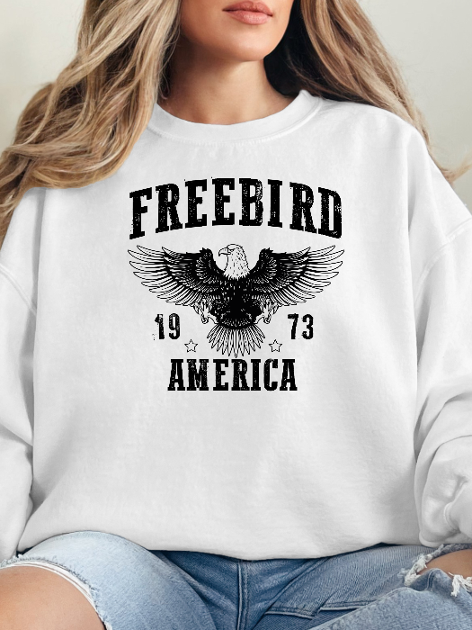 Women’s Freebird 1973 graphic tee featuring a bold Freebird America design, bald eagle graphic, black detailing, and vintage-inspired artwork on a Comfort Colors® cotton Crewneck in White