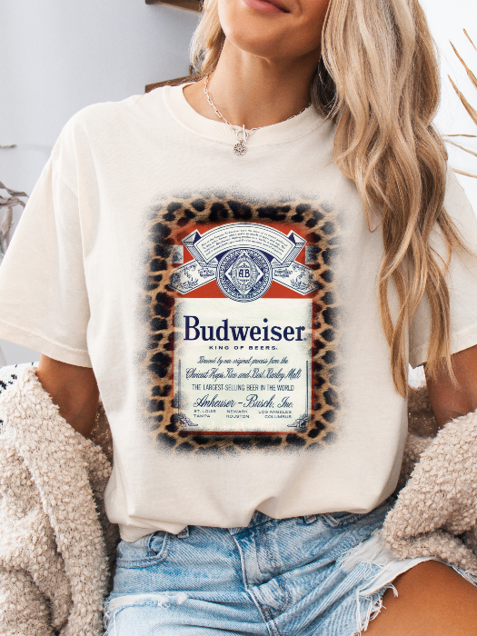 King of Beers Graphic Tee made from soft 100% cotton featuring a vintage-inspired beer graphic, perfect for tailgates, BBQs, brewery visits, country concerts, and casual everyday style. Color Ivory