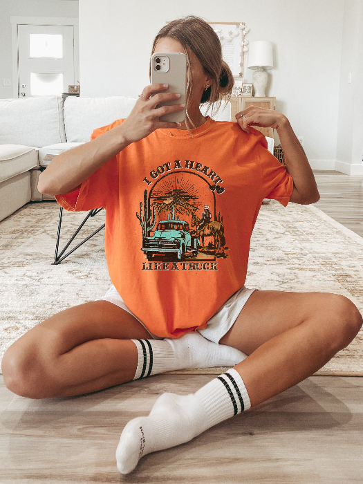 Heart Like A Truck Graphic Tee featuring an exclusive Willow Boutique country-inspired design on soft 100% cotton, perfect for country concerts, rodeos, Nashville trips, and everyday western style. Tshirt in Orange
