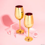 Set of two Barbie™ x Dragon Glassware® Dreamhouse™ 17.5 oz stemmed wine glasses with metallic gold exteriors, pink interiors, Barbie™ logo bases, and pink gift box.
