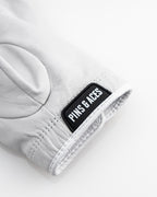 Pins & Aces Premium Tour Ghost White unisex golf glove made from 100% premium AAA Cabretta leather with moisture-wicking wrist lining and men’s standard sizing.
