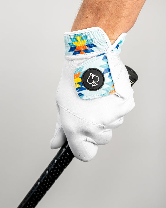 White Pins & Aces Southwest Sunset Premium Tour golf glove made from Cabretta leather with perforated fingers and a colorful Southwest-inspired wrist design.