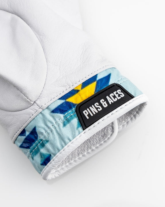 White Pins & Aces Southwest Sunset Premium Tour golf glove made from Cabretta leather with perforated fingers and a colorful Southwest-inspired wrist design.