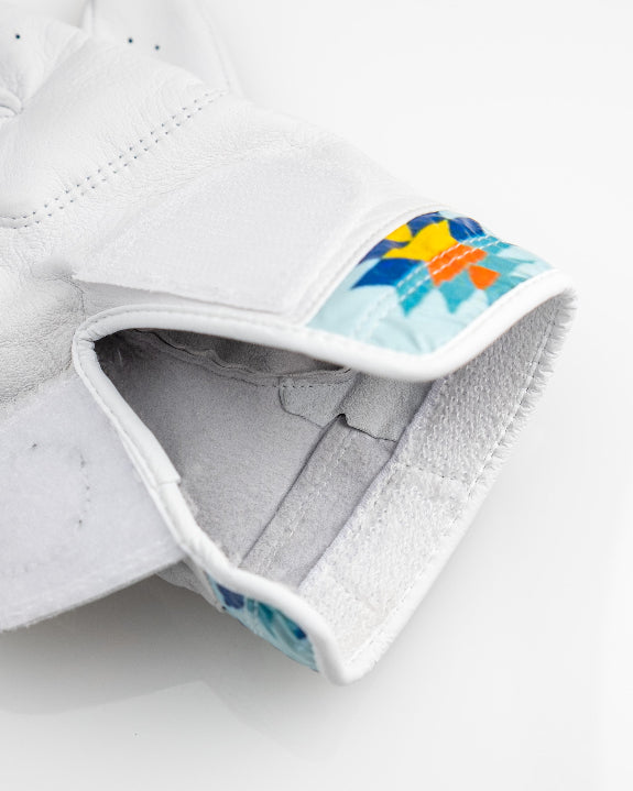 White Pins & Aces Southwest Sunset Premium Tour golf glove made from Cabretta leather with perforated fingers and a colorful Southwest-inspired wrist design.