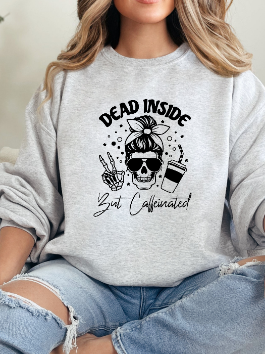 Dead Inside But Caffeinated graphic available as a tee, crewneck, or sweatshirt featuring a fun coffee-inspired design on soft cotton-blend fabric, perfect for Halloween, spooky season, and everyday fall outfits. Crewneck in Grey