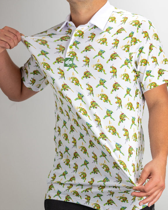 White TMNT Cowabunga Classic 8-Bit golf polo by Pins & Aces featuring an all-over retro pixel-style Teenage Mutant Ninja Turtles character print.