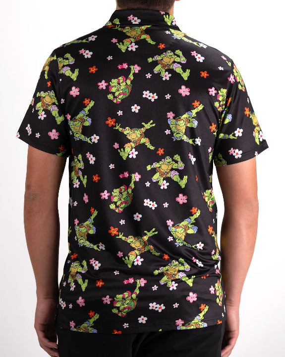 Black TMNT Turtle Flower Power golf polo by Pins & Aces featuring colorful Teenage Mutant Ninja Turtles characters and floral print.