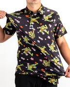 Black TMNT Turtle Flower Power golf polo by Pins & Aces featuring colorful Teenage Mutant Ninja Turtles characters and floral print.