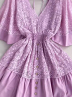 Hope Ruffle Hem Lace Mini Dress featuring delicate lace detailing, a flowy silhouette, feminine ruffle hem, and adjustable tie-back design, perfect for weddings, bridal showers, vacations, and spring or summer occasions. Color Lavender