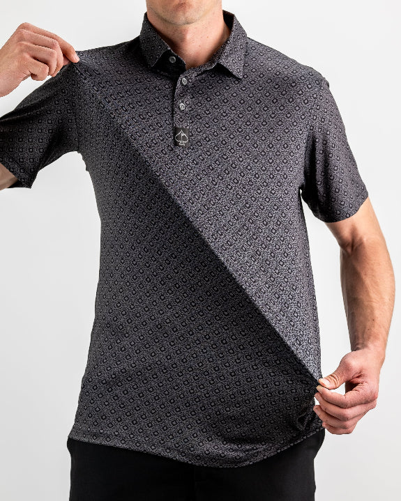 Men’s Big Blind golf polo by Pins & Aces featuring a subtle dark gray and black geometric pattern with short sleeves, collared neckline, and athletic fit.