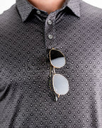 Men’s Big Blind golf polo by Pins & Aces featuring a subtle dark gray and black geometric pattern with short sleeves, collared neckline, and athletic fit.