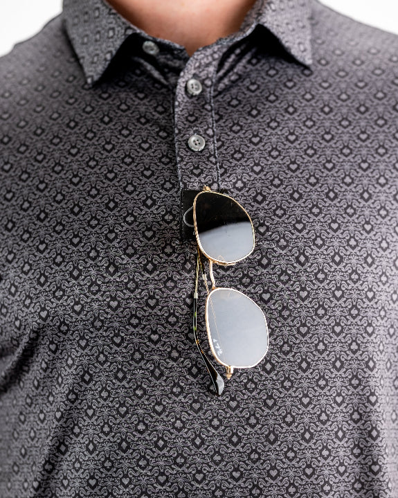 Men’s Big Blind golf polo by Pins & Aces featuring a subtle dark gray and black geometric pattern with short sleeves, collared neckline, and athletic fit.