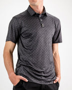 Men’s Big Blind golf polo by Pins & Aces featuring a subtle dark gray and black geometric pattern with short sleeves, collared neckline, and athletic fit.