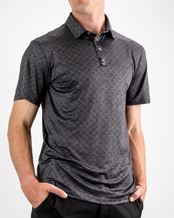 Men’s Big Blind golf polo by Pins & Aces featuring a subtle dark gray and black geometric pattern with short sleeves, collared neckline, and athletic fit.