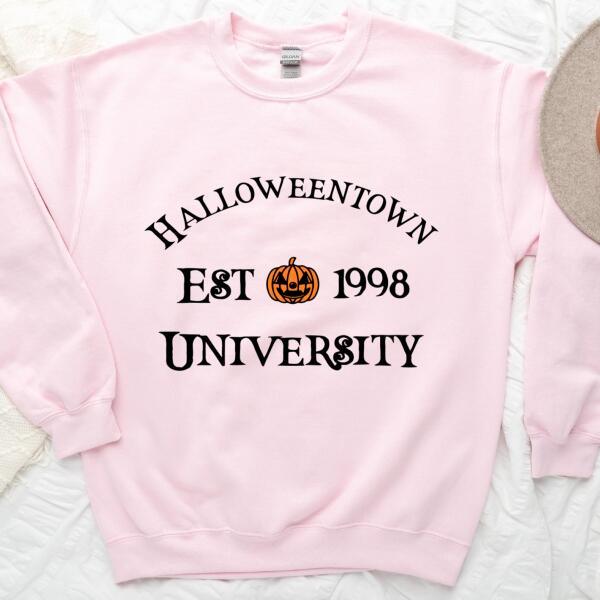 Halloweentown University Halloween sweatshirt featuring a collegiate-style spooky season graphic on a cozy crewneck in Light Pink