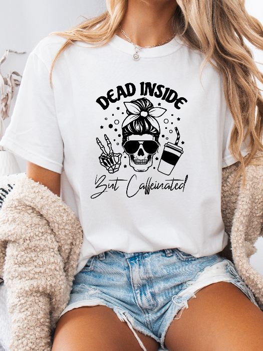 Dead Inside But Caffeinated graphic available as a tee, crewneck, or sweatshirt featuring a fun coffee-inspired design on soft cotton-blend fabric, perfect for Halloween, spooky season, and everyday fall outfits. TShirt in White