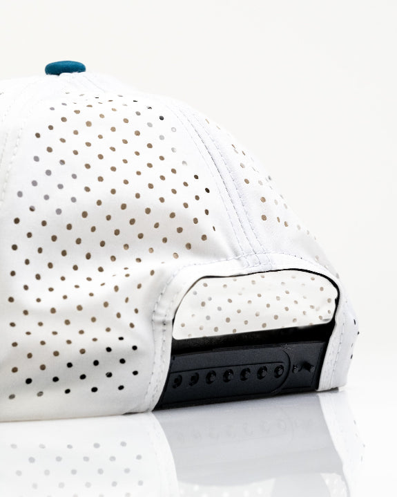 White Pins & Aces Fishing Lure perforated rope golf hat with fishing-inspired design, adjustable snapback, magnetic ball marker holder, and matching golf ball marker.
