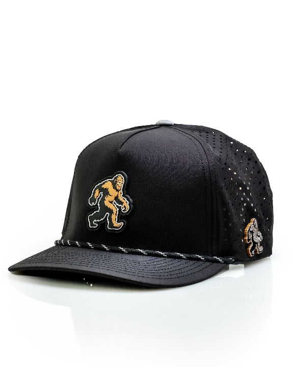 Pins & Aces Sasquatch Black perforated golf rope hat with adjustable snapback, magnetic ball marker holder, and matching golf ball marker.