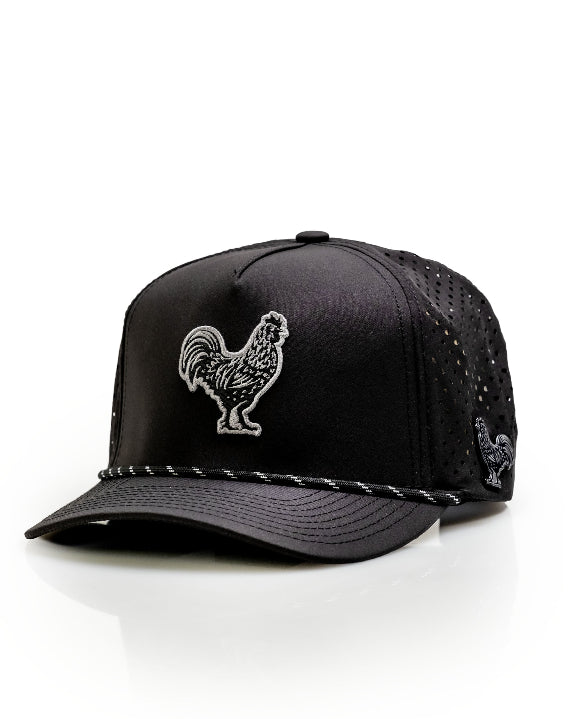 Black Pins & Aces perforated rope golf hat featuring an embroidered rooster on the front, breathable side panels, rope detail, and adjustable snapback design.