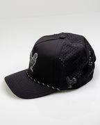Black Pins & Aces perforated rope golf hat featuring an embroidered rooster on the front, breathable side panels, rope detail, and adjustable snapback design.