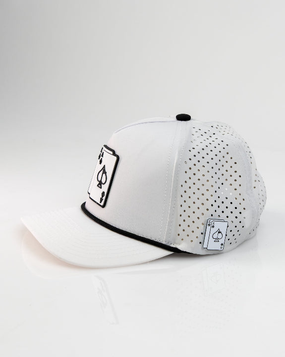 Ace/King White perforated rope golf hat by Pins & Aces with an adjustable snapback, built-in magnetic ball marker holder, and matching golf ball marker.