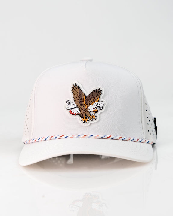 Freedom Eagle White perforated rope golf hat by Pins & Aces featuring a patriotic eagle design, adjustable snapback, magnetic ball marker holder, and matching golf ball marker.
