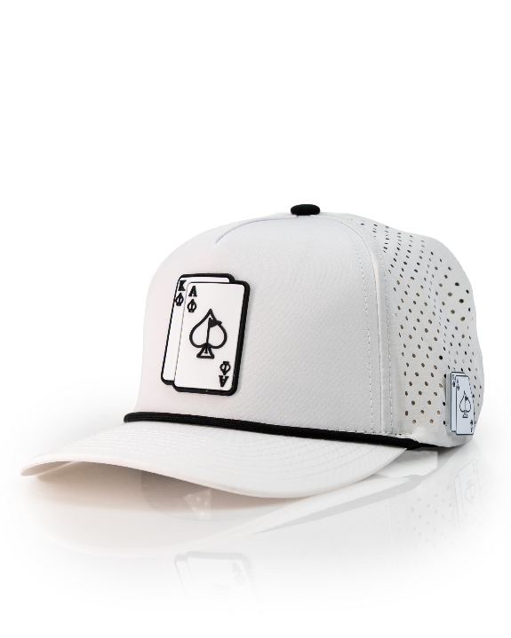 Ace/King White perforated rope golf hat by Pins & Aces with an adjustable snapback, built-in magnetic ball marker holder, and matching golf ball marker.
