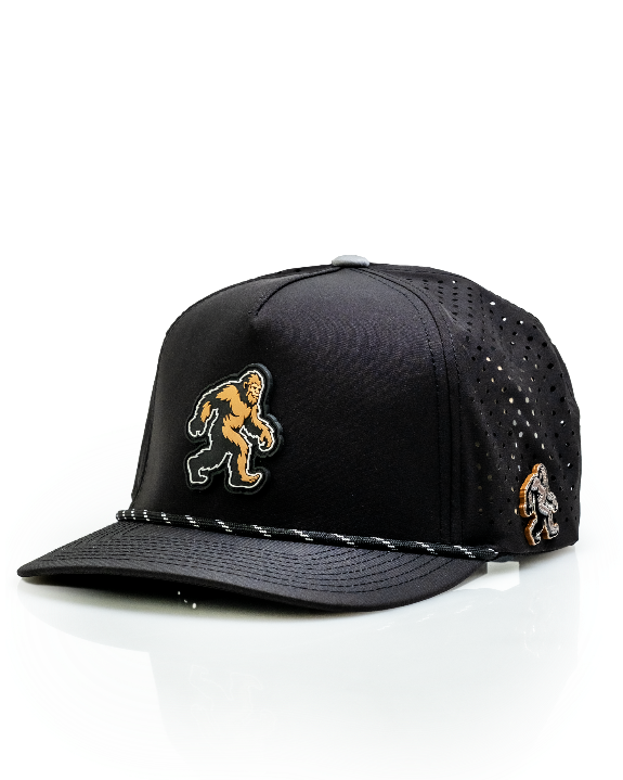 Pins & Aces Sasquatch Black perforated golf rope hat with adjustable snapback, magnetic ball marker holder, and matching golf ball marker.