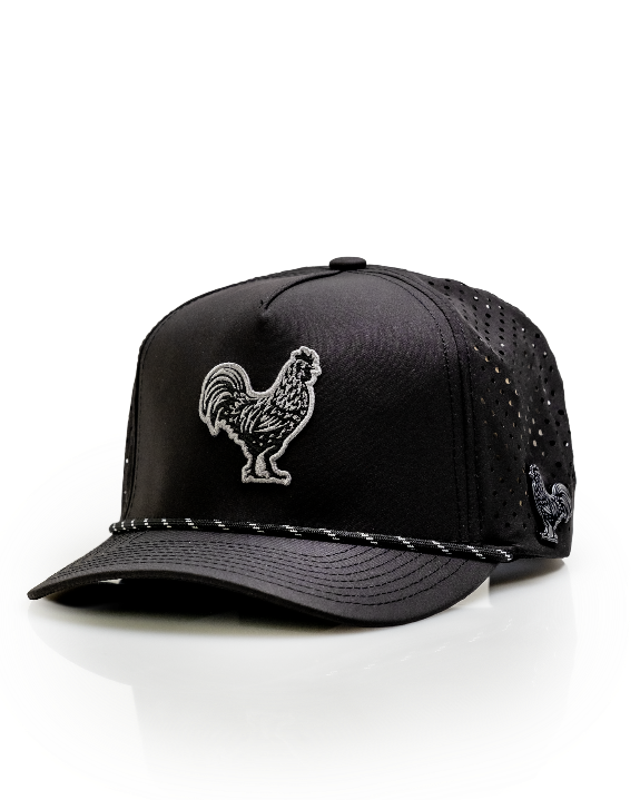 Black Pins & Aces perforated rope golf hat featuring an embroidered rooster on the front, breathable side panels, rope detail, and adjustable snapback design.