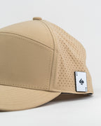 Tradesman Sand golf hat by Pins & Aces featuring a warm neutral sand colorway, adjustable snapback closure, and built-in magnetic golf ball marker holder.