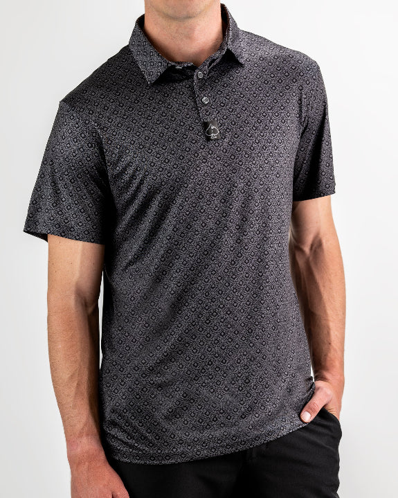 Men’s Big Blind golf polo by Pins & Aces featuring a subtle dark gray and black geometric pattern with short sleeves, collared neckline, and athletic fit.