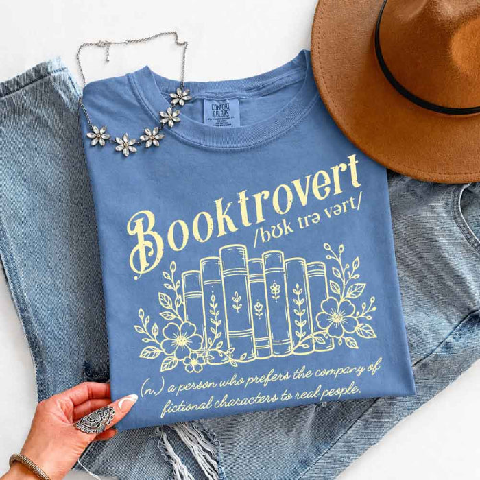 Booktrovert Comfort Colors T-shirt featuring a playful book lover graphic on a relaxed garment-dyed 100% cotton tee for readers and bookworms in color Blue Jean