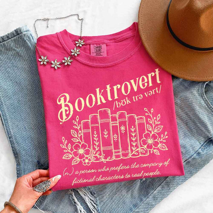 Booktrovert Comfort Colors T-shirt featuring a playful book lover graphic on a relaxed garment-dyed 100% cotton tee for readers and bookworms in color Crunchberry