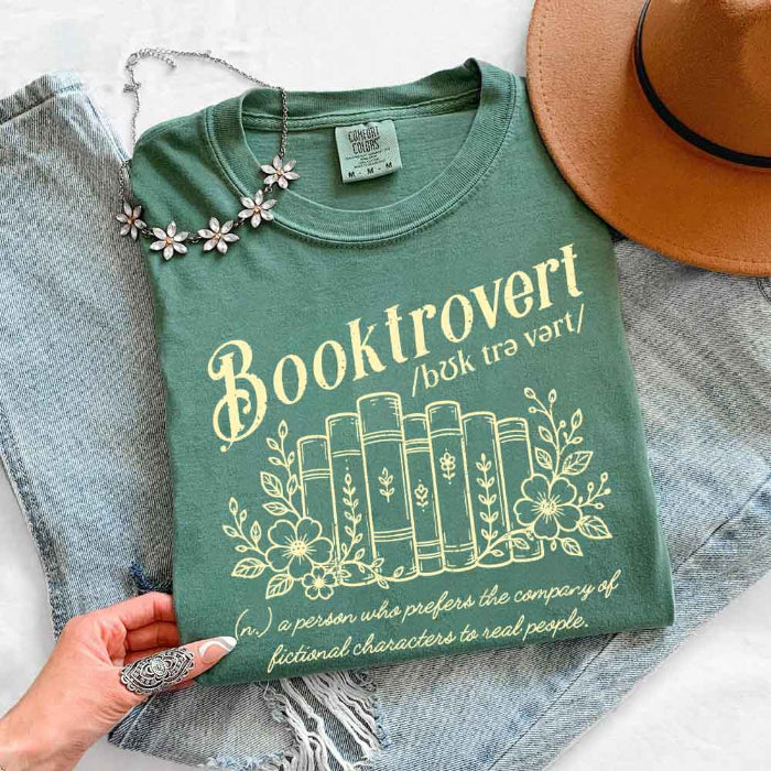 Booktrovert Comfort Colors T-shirt featuring a playful book lover graphic on a relaxed garment-dyed 100% cotton tee for readers and bookworms in color Light Green