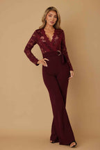 Women’s lace crochet long sleeve jumpsuit featuring sheer mesh detailing, a plunging V-neckline, adjustable D-ring waist belt, and flared legs.