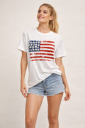Women's patriotic graphic tee with distressed American flag print, crew neckline, and short sleeves