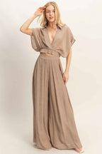 Women’s two-piece set featuring a cropped collared wrap top with soft pleating and coordinating flowy wide-leg pants in a lightweight cotton-rayon blend.