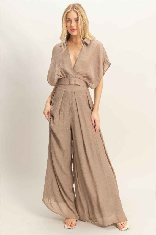 Women’s two-piece set featuring a cropped collared wrap top with soft pleating and coordinating flowy wide-leg pants in a lightweight cotton-rayon blend.