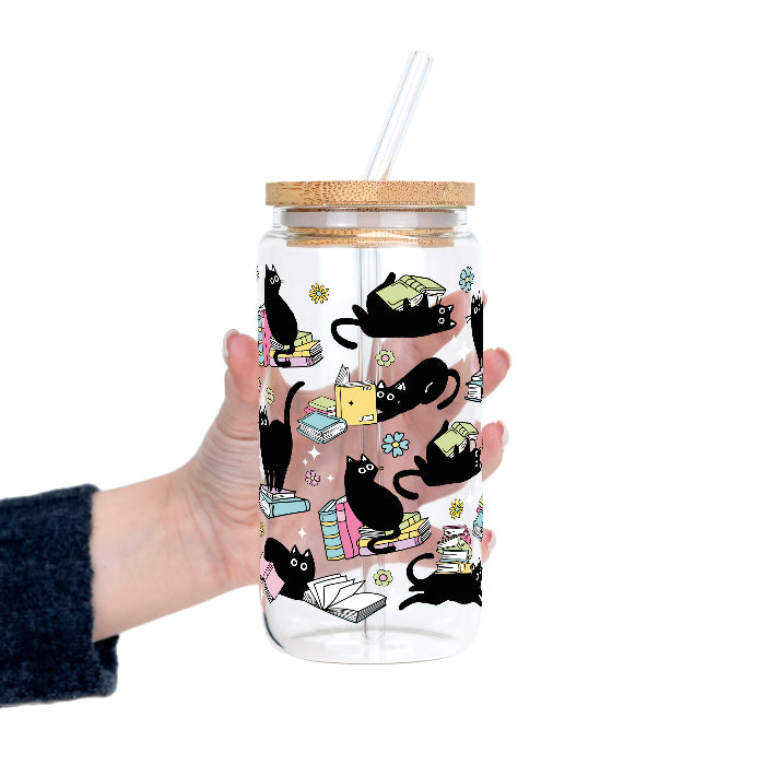 Black Cats on Books drinkware design featuring whimsical black cats lounging on colorful stacks of books with pastel flowers and bookish details.