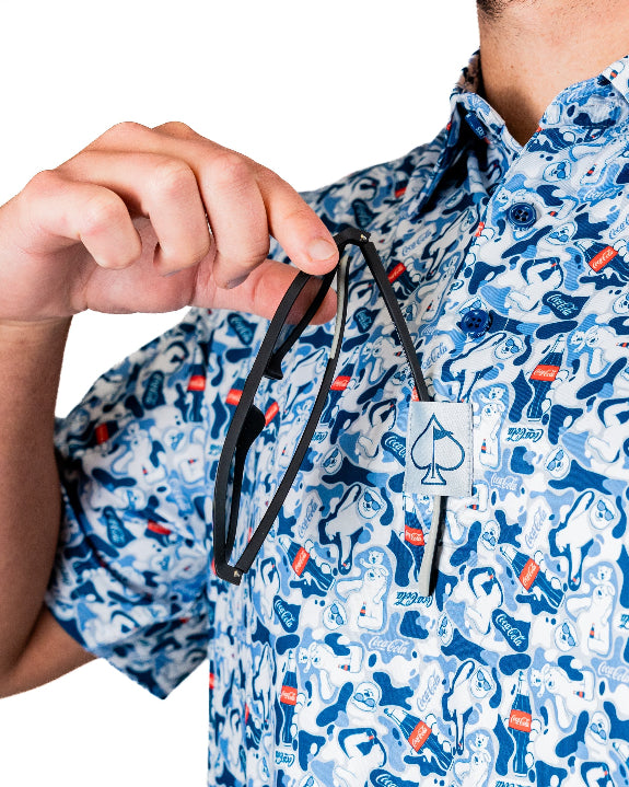 Men’s Coca-Cola golf polo from the official Coca-Cola x Pins & Aces collaboration featuring a blue and white all-over print with red accents and an athletic performance fit.