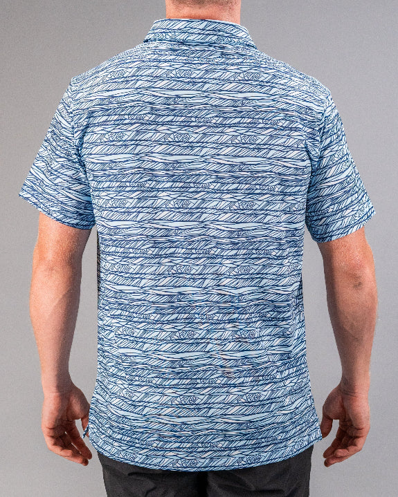 Men’s Fragment Blue golf polo by Pins & Aces featuring an all-over abstract fragmented line pattern in blue and white with short sleeves and an athletic performance fit.