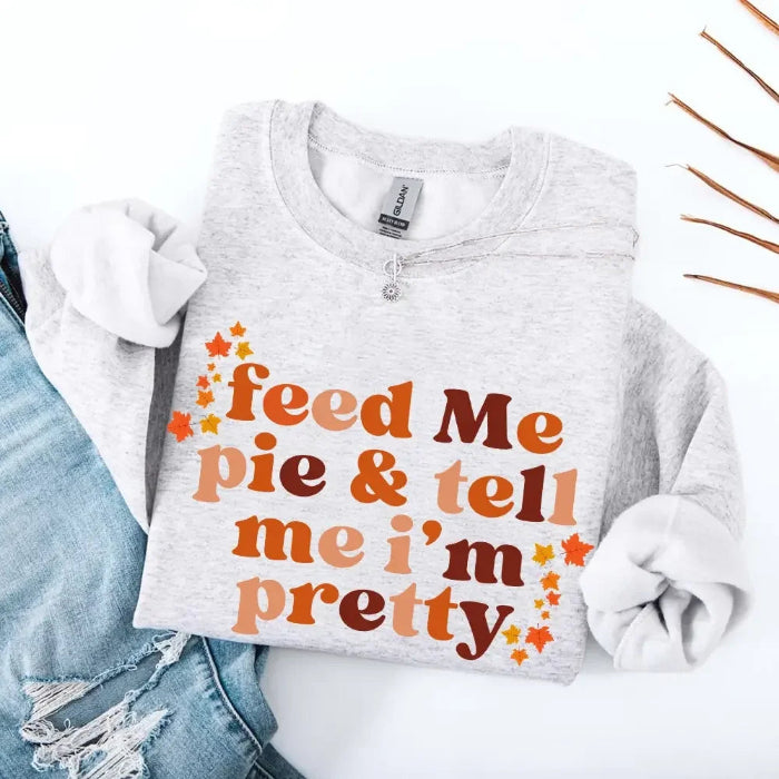 Feed Me Pie and Tell Me I’m Pretty funny Thanksgiving sweatshirt featuring a fall pie lover graphic on a cozy unisex crewneck in Ash