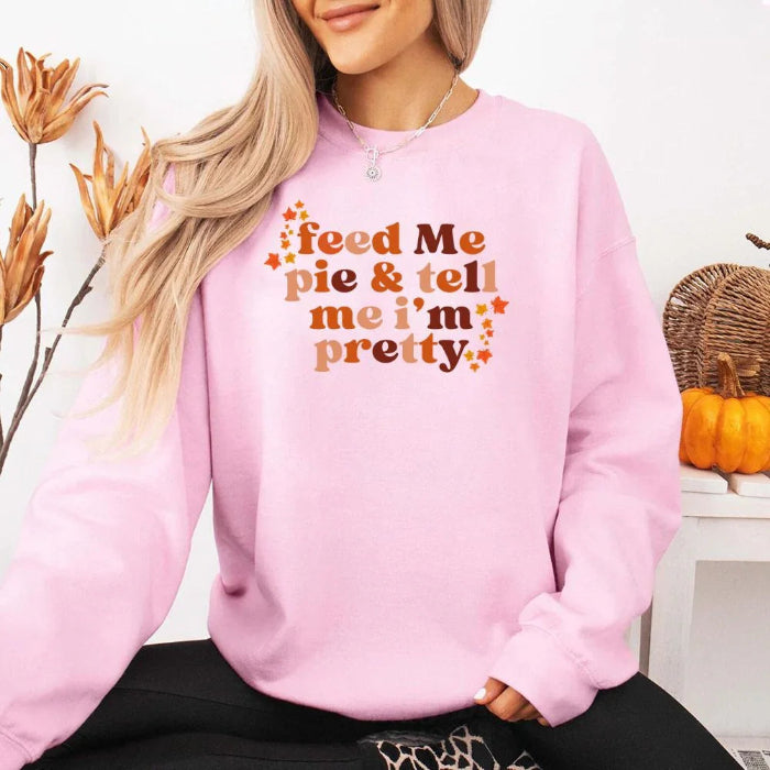 Feed Me Pie and Tell Me I’m Pretty funny Thanksgiving sweatshirt featuring a fall pie lover graphic on a cozy unisex crewneck in Light Pink