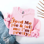 Feed Me Pie and Tell Me I’m Pretty funny Thanksgiving sweatshirt featuring a fall pie lover graphic on a cozy unisex crewneck in Light Pink