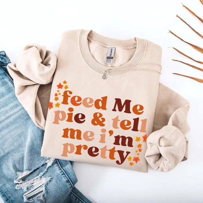 Feed Me Pie and Tell Me I’m Pretty funny Thanksgiving sweatshirt featuring a fall pie lover graphic on a cozy unisex crewneck in Sand