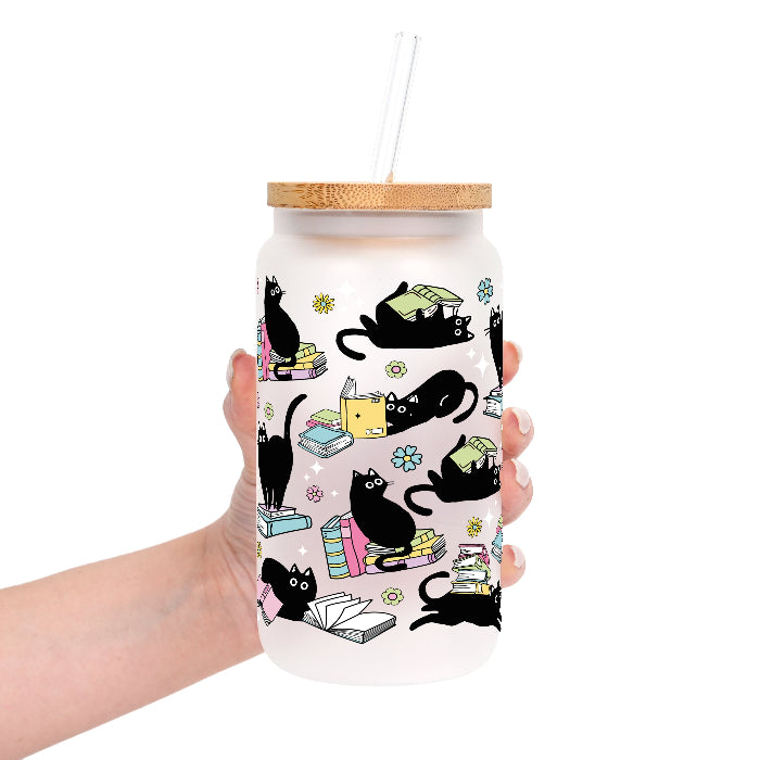 Black Cats on Books drinkware design featuring whimsical black cats lounging on colorful stacks of books with pastel flowers and bookish details.