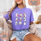 Ghost Reading Comfort Colors T-shirt featuring a whimsical ghost reading a book on a relaxed garment-dyed cotton Halloween graphic tee for book lovers in Violet