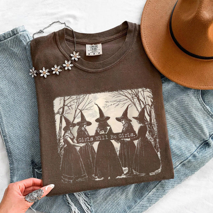 Girls Will Be Girls Comfort Colors graphic T-shirt with a playful Halloween-inspired design for spooky season in Espresso
