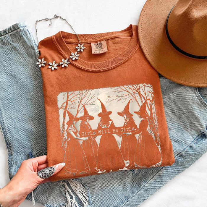 Girls Will Be Girls Comfort Colors graphic T-shirt with a playful Halloween-inspired design for spooky season in Yam